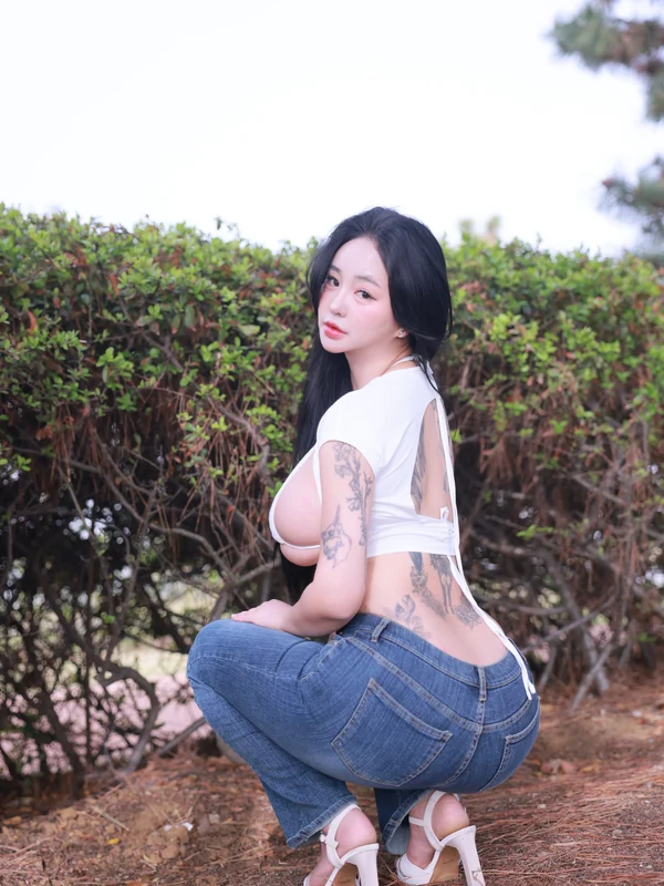 171jun01 Jeon Boyeon นั่งยองหันหลังในเสื้อสีขาวและกางเกงยีนส์